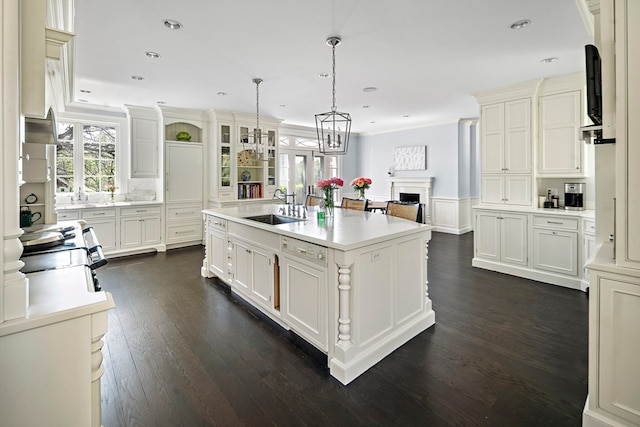 kitchen featuring hanging light fixtures, sink, dark hardwood / wood-style floors, and a kitchen island with sink