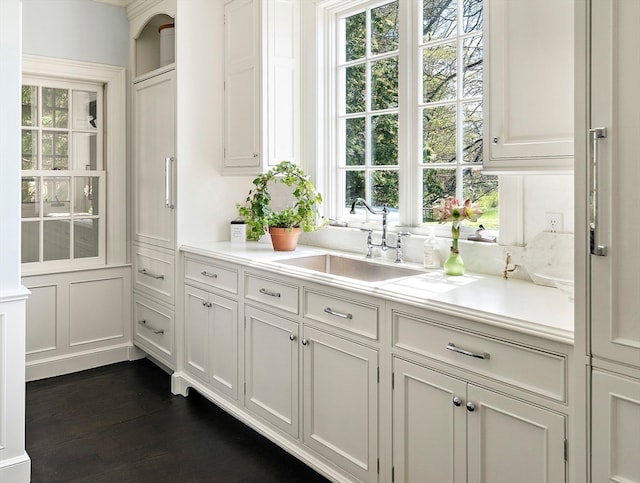 kitchen with sink, dark hardwood / wood-style flooring, and white cabinets