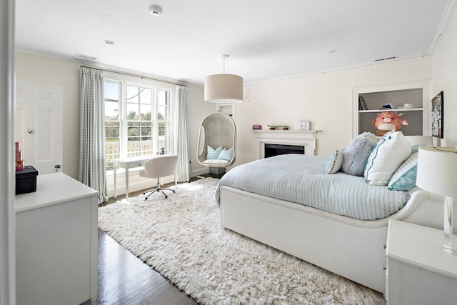 bedroom with ornamental molding and hardwood / wood-style flooring