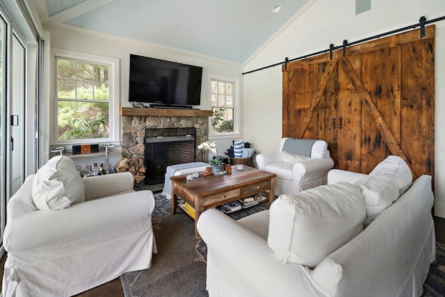 living room featuring a barn door, vaulted ceiling, and a fireplace