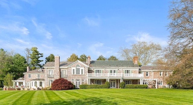 rear view of house featuring a lawn