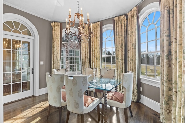 dining area featuring a notable chandelier, dark wood-type flooring, and ornamental molding