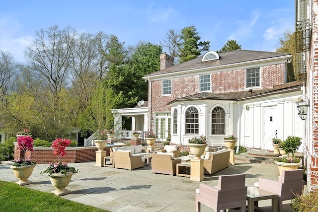 back of house featuring outdoor lounge area and a patio