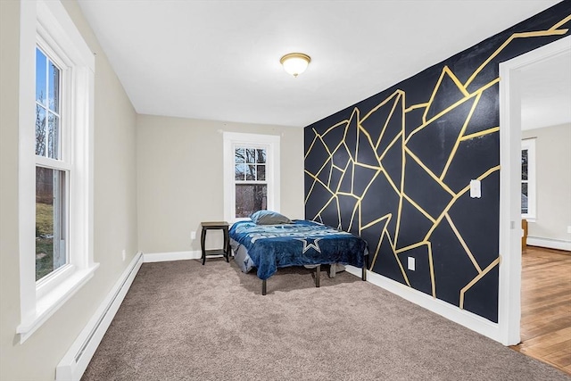 bedroom featuring hardwood / wood-style floors and a baseboard heating unit