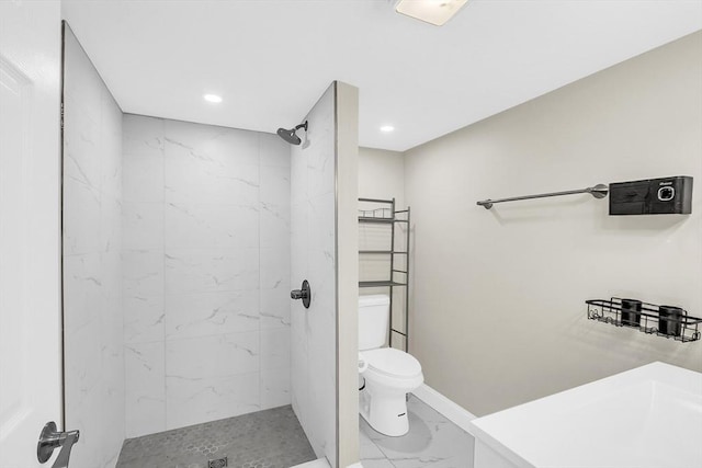 bathroom featuring toilet and a tile shower