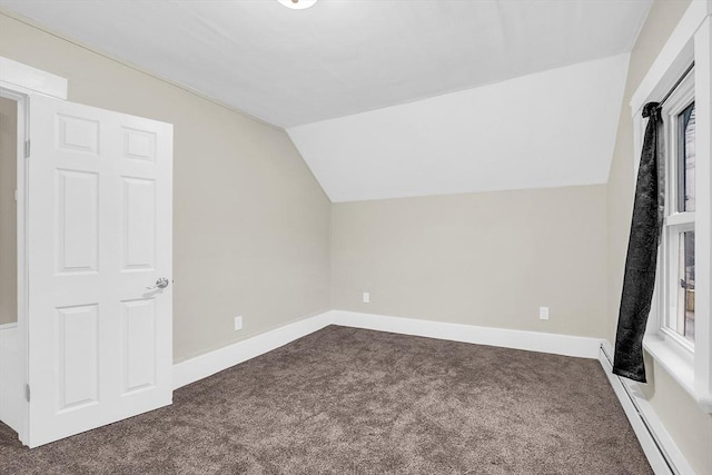 additional living space with dark colored carpet, lofted ceiling, and a baseboard radiator