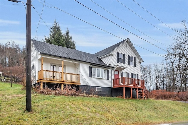 rear view of house with a deck and a lawn