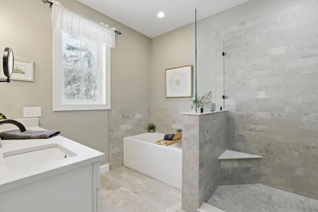 bathroom with vanity, walk in shower, and a bath