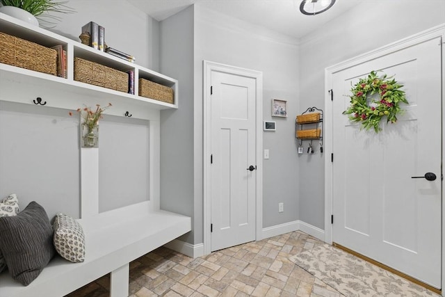 mudroom with brick floor and baseboards