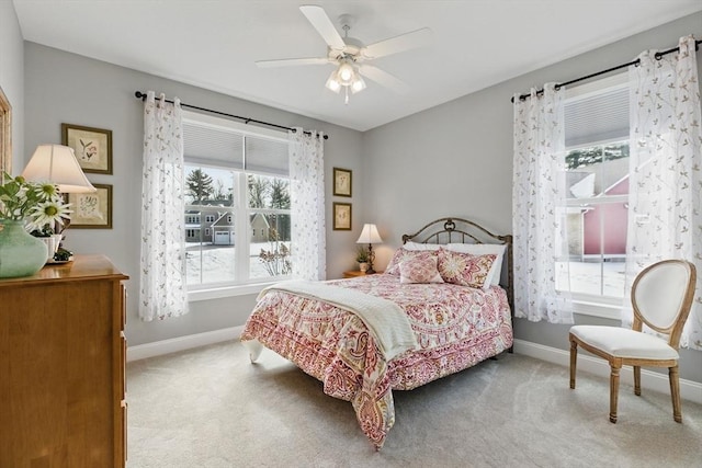 carpeted bedroom featuring baseboards and a ceiling fan