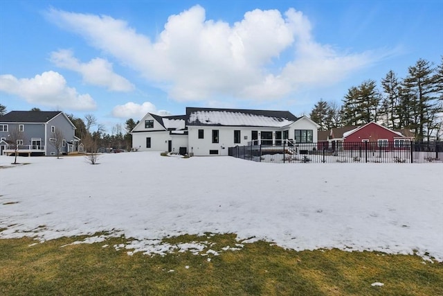 snow covered house with fence