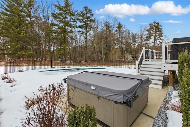 yard layered in snow featuring a hot tub, stairs, and fence