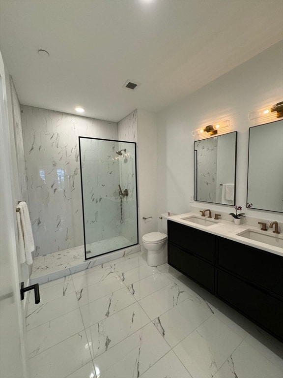 bathroom with vanity, toilet, and a shower with door