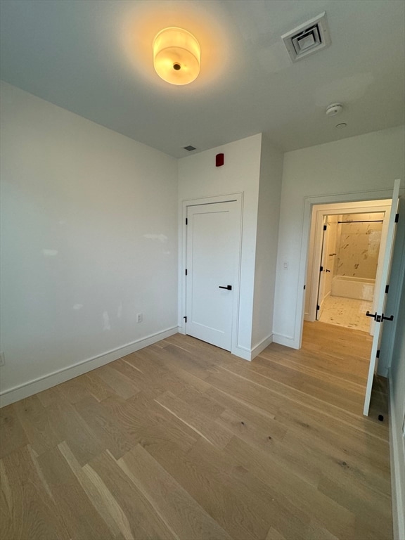 unfurnished bedroom with a closet and light hardwood / wood-style flooring