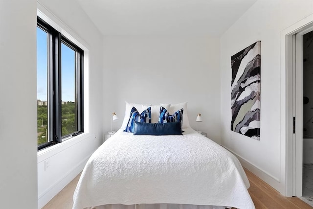 bedroom featuring multiple windows and light hardwood / wood-style flooring