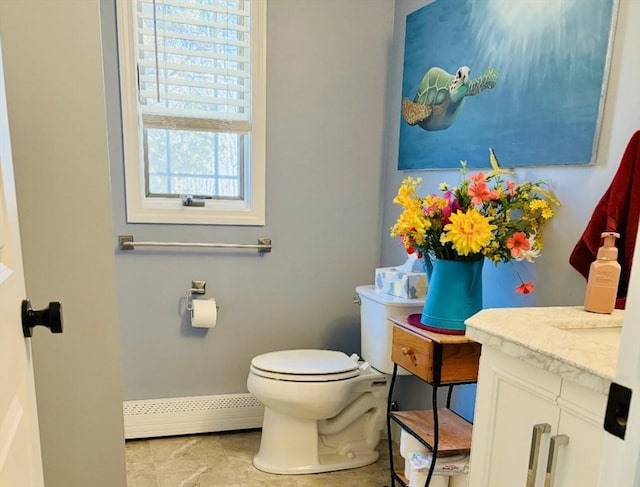 half bathroom featuring vanity, toilet, and a baseboard heating unit