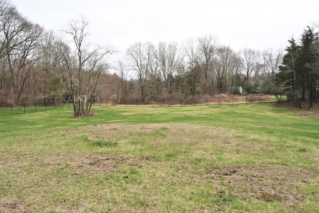 view of yard with fence and a view of trees