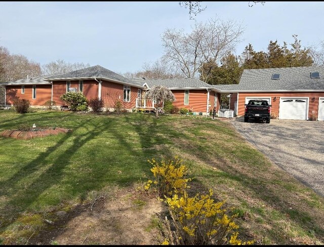 view of front of property with a front yard, driveway, and a garage
