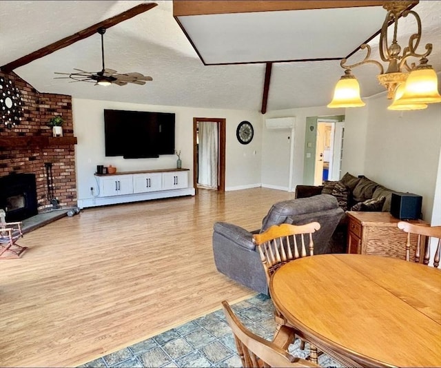 living room with a textured ceiling, a ceiling fan, and vaulted ceiling with beams