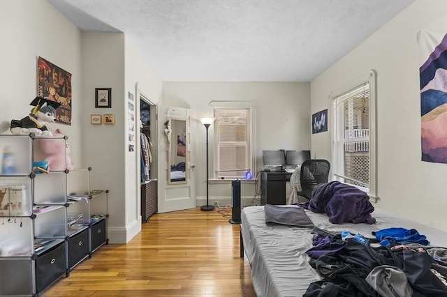 35 Ibbetson, Somerville, MA 02143 - bedroom with multiple windows, light wood finished floors, a textured ceiling, and baseboards