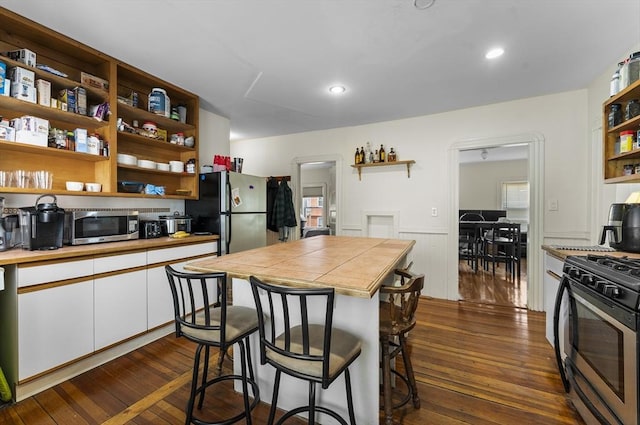 35 Ibbetson, Somerville, MA 02143 - kitchen featuring open shelves, appliances with stainless steel finishes, white cabinetry, wainscoting, and dark wood-type flooring