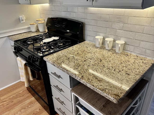80 Brush Hill Ave Unit 19, West Springfield, MA 01089 - kitchen with black range with gas cooktop, light wood finished floors, light stone countertops, and decorative backsplash