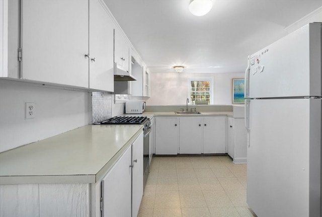 kitchen with decorative backsplash, white cabinetry, sink, and white appliances