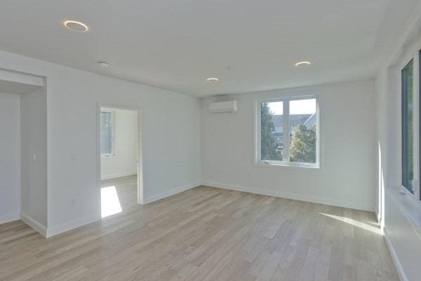 empty room featuring light hardwood / wood-style floors and a wall unit AC