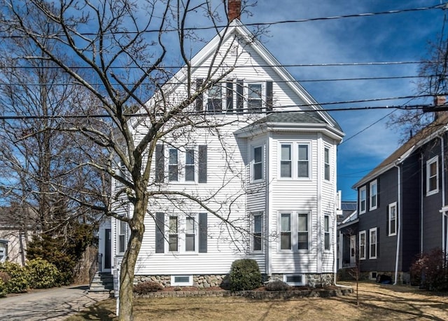 view of front of house with entry steps and a chimney