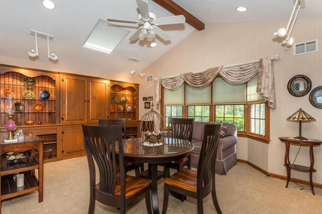 dining area featuring visible vents, lofted ceiling with beams, ceiling fan, and light carpet