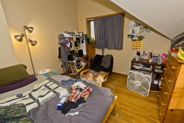 bedroom with hardwood / wood-style flooring and vaulted ceiling