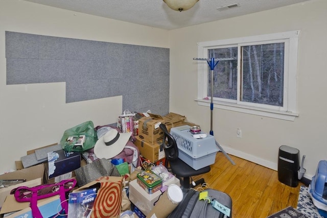 misc room featuring wood-type flooring and a textured ceiling