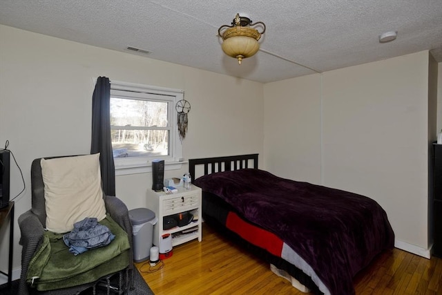 bedroom featuring wood-type flooring and a textured ceiling