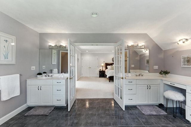 22 Campbell Rd, Middleton, MA 01949 - ensuite bathroom with french doors, two vanities, tile patterned floors, and lofted ceiling