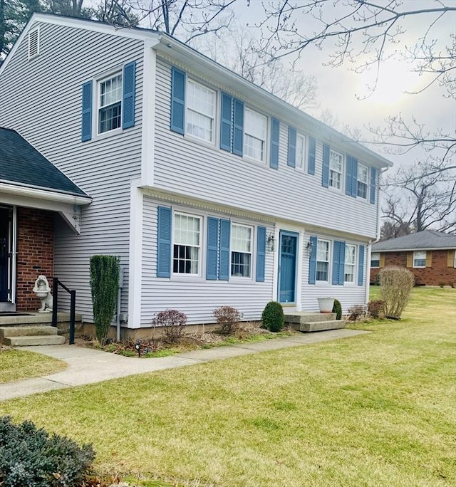 colonial inspired home with a front lawn