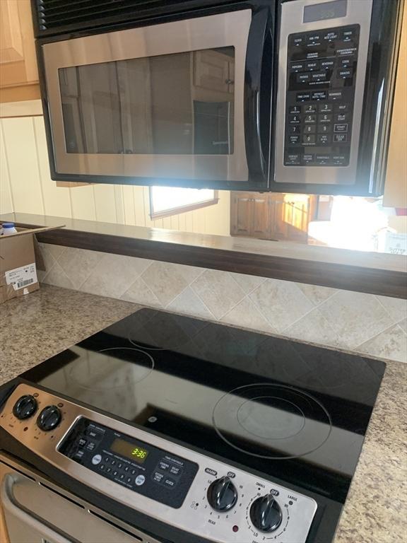 kitchen featuring tasteful backsplash, mail area, and appliances with stainless steel finishes