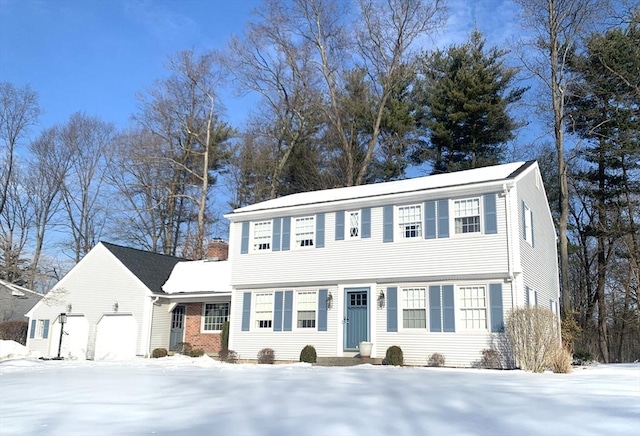 colonial home featuring an attached garage and brick siding