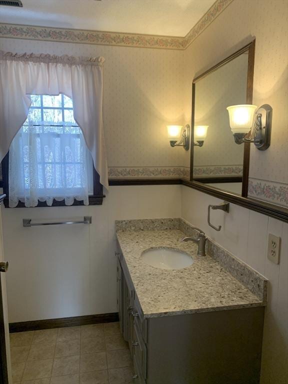 bathroom featuring baseboards, wainscoting, vanity, and wallpapered walls