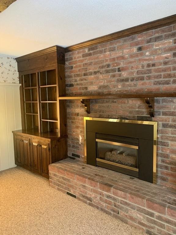 room details featuring carpet floors, wainscoting, a fireplace, and a textured ceiling