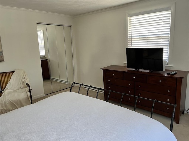 carpeted bedroom with a closet and crown molding