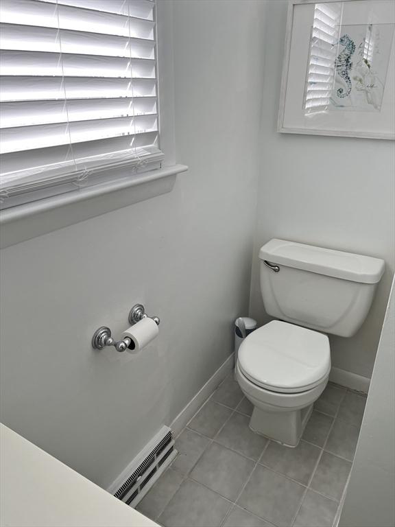 bathroom with baseboards, visible vents, toilet, and tile patterned floors