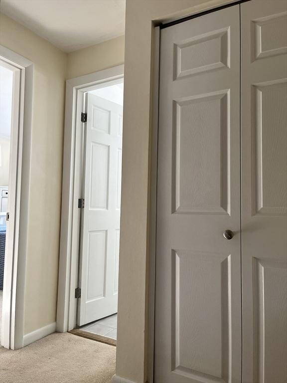 hallway featuring carpet floors and baseboards