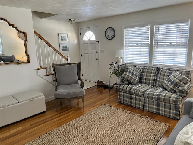 living room with stairway, baseboards, and wood finished floors