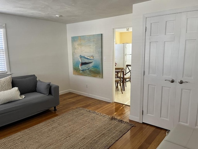 sitting room featuring baseboards and wood finished floors