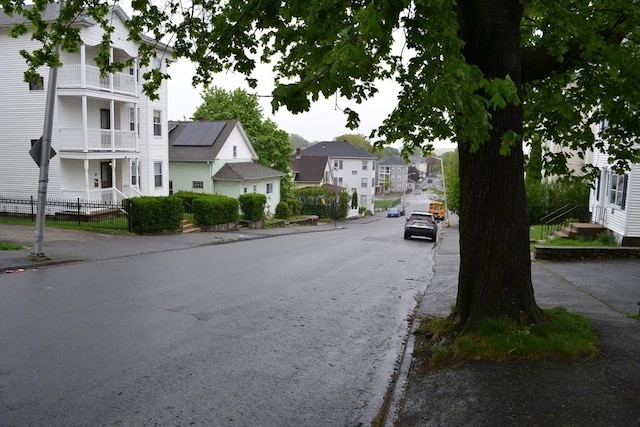 view of street with curbs, sidewalks, and a residential view