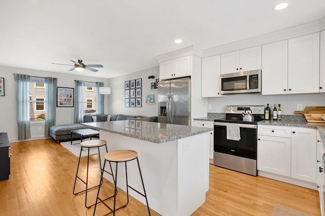 111 Union St Unit 8, Westfield, MA 01085 - kitchen featuring stainless steel appliances, open floor plan, a kitchen island, white cabinets, and recessed lighting