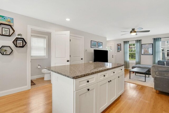 111 Union St Unit 8, Westfield, MA 01085 - kitchen featuring open floor plan, light wood finished floors, ceiling fan, a center island, and white cabinets