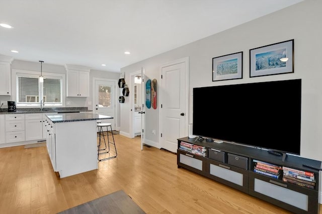 111 Union St Unit 8, Westfield, MA 01085 - kitchen with a kitchen bar, a center island, white cabinetry, light wood finished floors, and recessed lighting