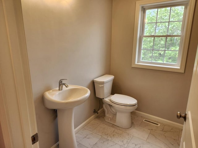 56 Kelly Ln, Lynn, MA 01904 - half bath featuring baseboards, toilet, marble look tile flooring, and healthy amount of natural light