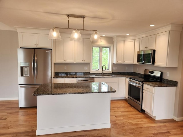 56 Kelly Ln, Lynn, MA 01904 - kitchen with stainless steel appliances, a sink, a center island, white cabinetry, and dark stone countertops